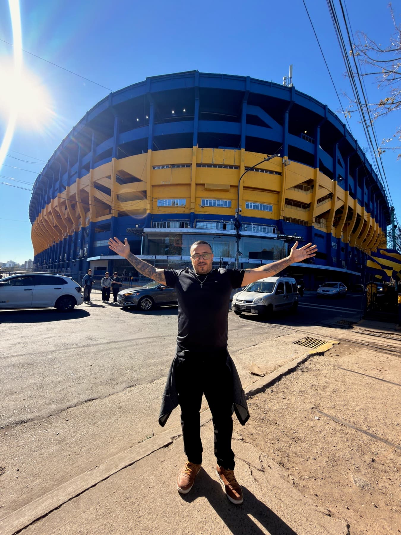 Turista de braços abertos em frente ao estádio La Bombonera, do Boca Juniors