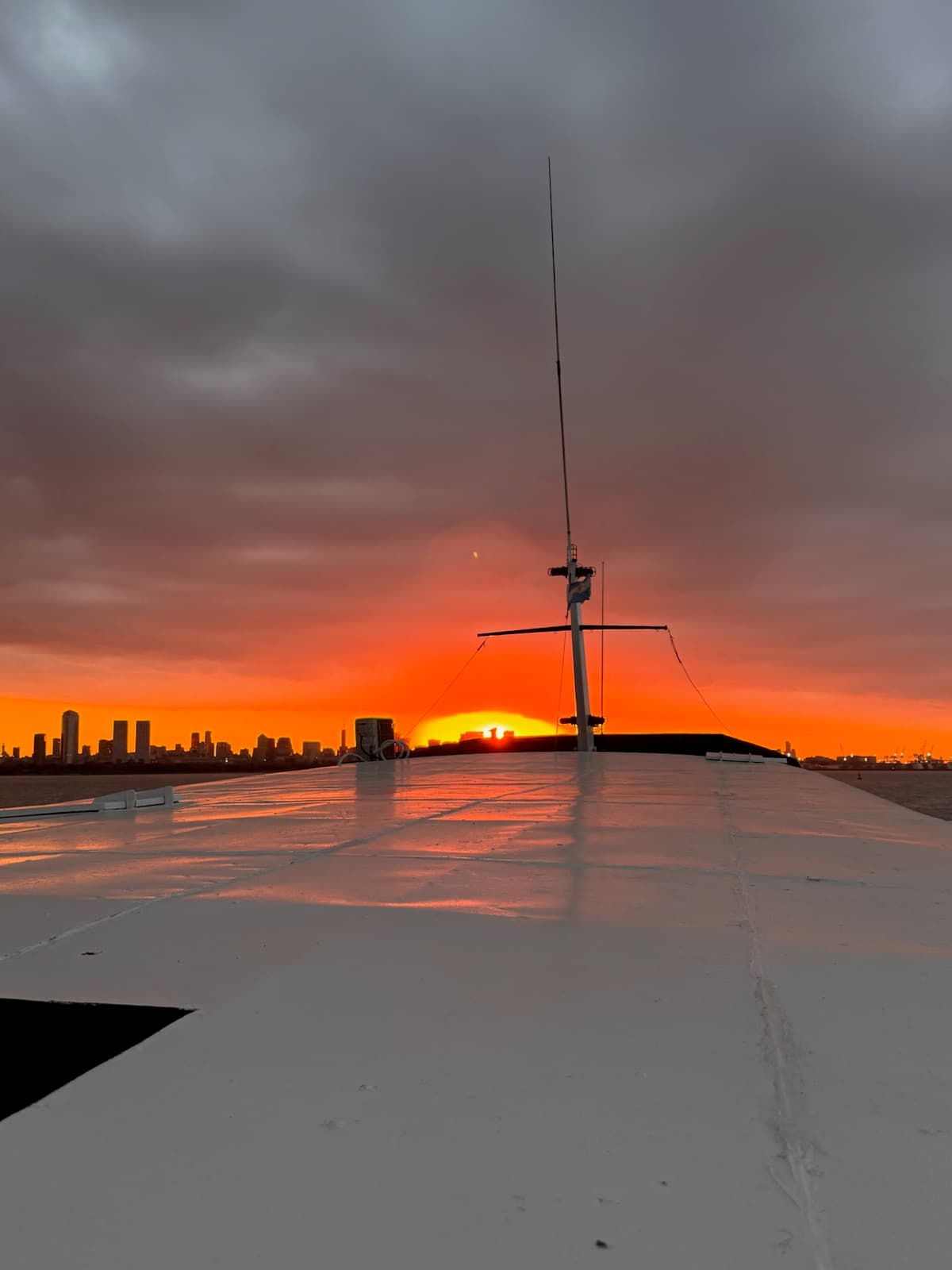 Céu alaranjado no pôr do sol visto do Rio da Prata, com o skyline de Puerto Madero